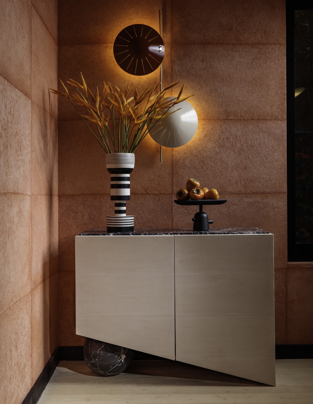 A corner with a bar cabinet and designer wall sconces